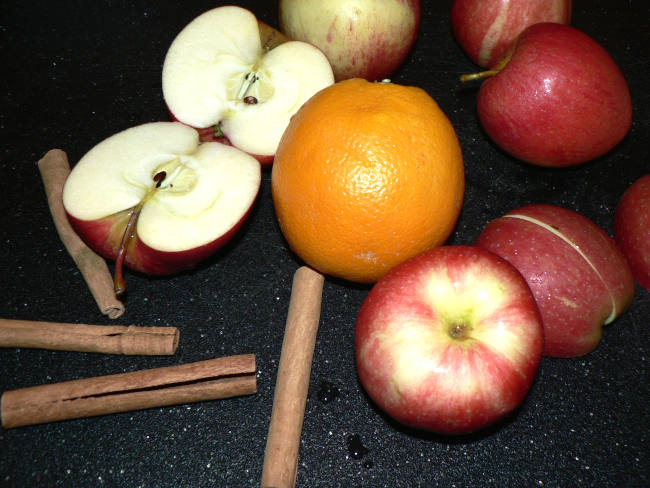 Apples and Orange on a black cutting board