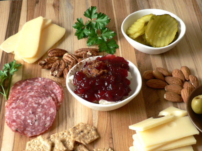 Cheese, meat, crackers on wooden board