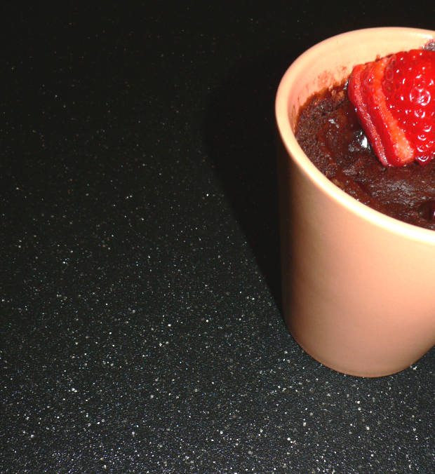 Chocolate cake in a mug with a strawberry on top