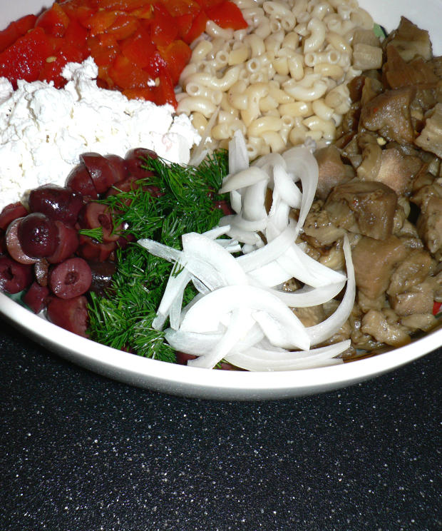 Chopped roasted eggplants, red bell peppers, onions, dill, olives, Feta, pasta, onions in a large bowl