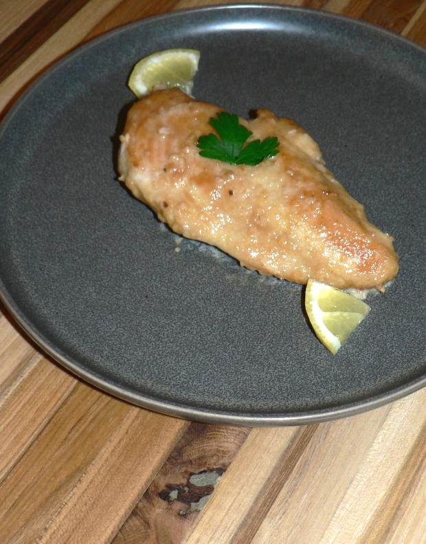 Chicken and Slices of Lemon on a Gray Plate