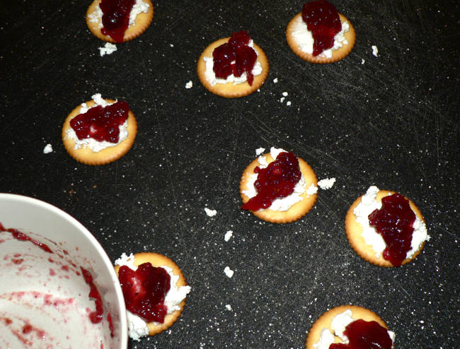 Crackers with Goat Cheese and Cranberries on a Cutting Board
