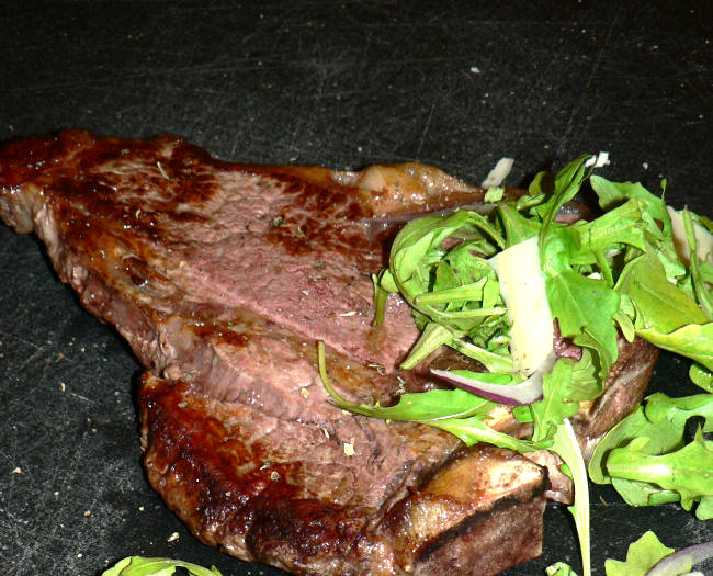 T-bone Steak with Arugula and Parmesan on top
