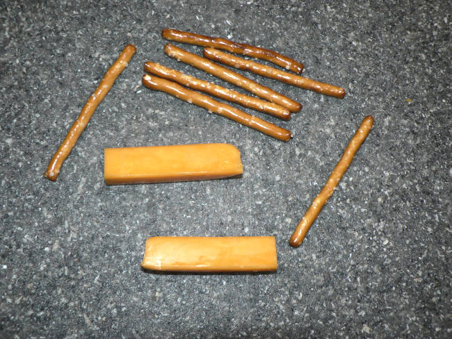 Cheese sticks and pretzels on a cutting board