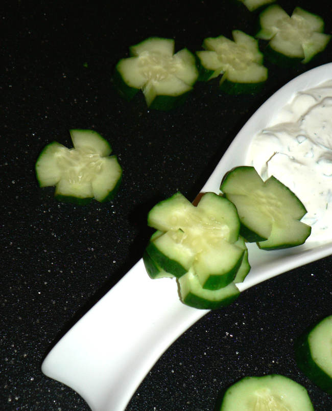 Cucumber clovers with dressing on a cutting board