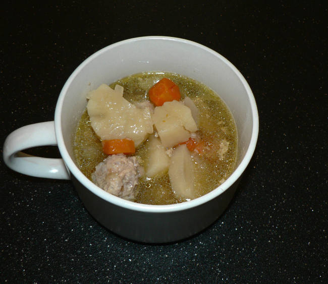 Porcupine Turkey Meatball Soup in a cut on a black cutting board