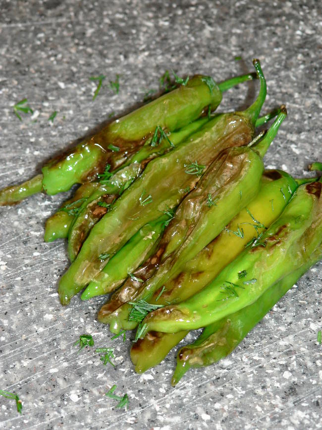 Blistered Shishito Peppers on a grey cutting board