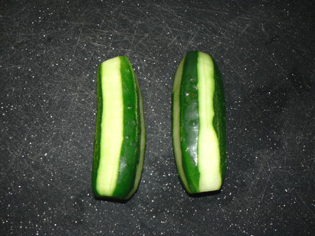 Peeled cucumbers on a black cutting board